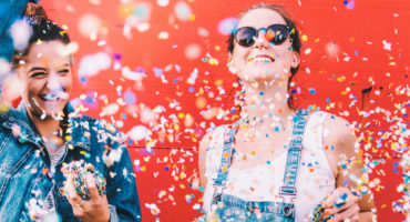 Hipster girlfriends celebrating with confetti