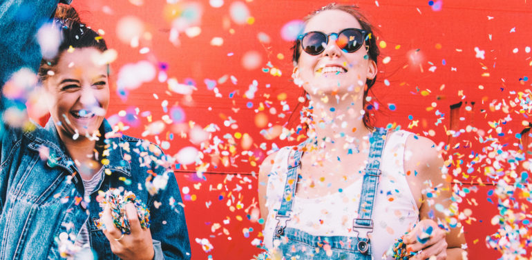 Hipster girlfriends celebrating with confetti